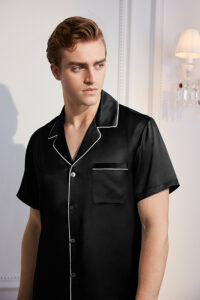 Man wearing Authentic Men's Short Sleeve Silk Pajama Set in classic black with white piping detail.
