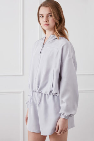 Woman wearing light gray Athflow women's sun protection hoodie set, side view.