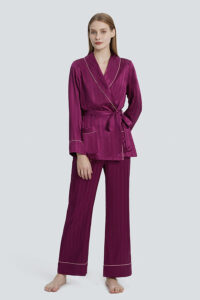 A woman in a MANITO Embossed purple pajama set, standing against a light background.