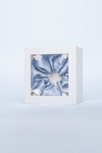 Two-tone Silk Scrunchie in classic peony white creates a sweet vintage look, beautifully displayed in a gift box at the center.