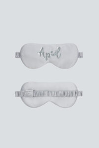 Silver-gray Lune Silk Eye Mask with “April” sequin embroidery and silk-covered strap.