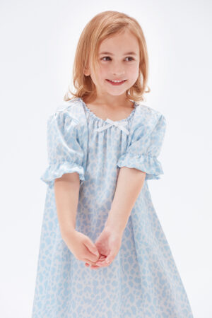 Smiling little girl in a blue leopard print silk nightgow.