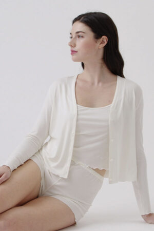 Woman in New Soft white camisole set with long sleeve cardigan, made from soft and stretchy fabric.