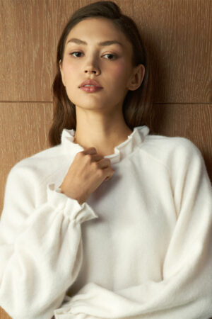 Close-up of woman wearing Purity Drawstring Set in snow white, showing a soft ruffled neckline and smooth texture.