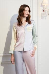 Woman wearing MANITO Macaron Silk Pajama Set indoors, showing macaron-colored design.