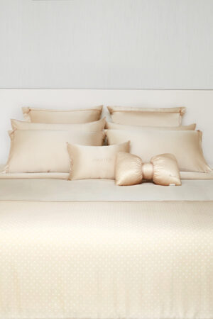 Elegant bed setup featuring MANITO Ribbon Silk Pillowcases with delicate ribbon ties and classic polka dots for a refined look.