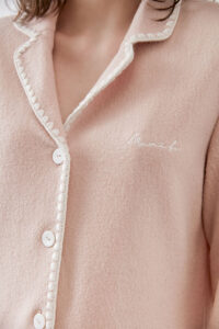A close-up of Shell Women's Cashmere Pink Lounge Top, emphasizing the delicate embroidery and button details.