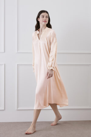 Woman in moonlight pink midi dress in motion, showcasing dynamic beauty of the dress with V-neck pleats and ruffled lantern sleeves.