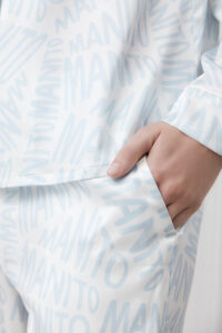 Detail of the pocket of a blue Script Silk Pajama Set for women, accentuating the subtle branding and premium material.