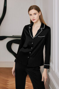 Woman in elegant Pearlwear Silk Pajama Set with pearl piping detail, showcasing sophistication and comfort.